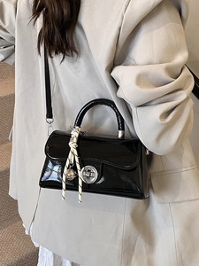 Sac bandoulière élégant en cuir verni noir avec fermoir argenté et charm tissé