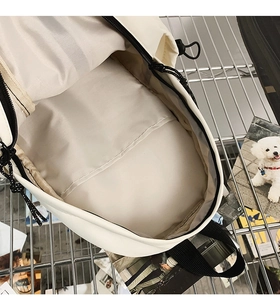 Detail view of the spacious main compartment and interior pocket of the beige crossbody bag