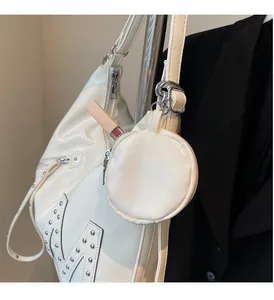 Detail of white half-moon shoulder bag with stud decor and small pouch for lip gloss