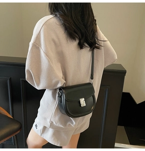 Detailed back view of a black leather saddle bag featuring a silver metal square buckle