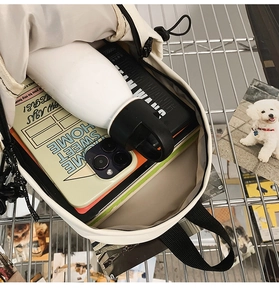 Detailed top view of large capacity white nylon sling bag showing spacious interior storage