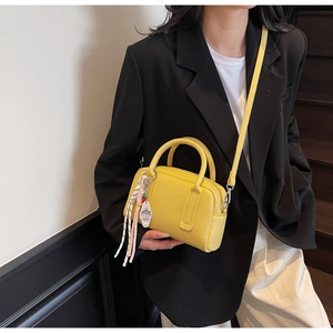 Detail of yellow lychee texture leather handbag featuring 1885 tag and silver hardware