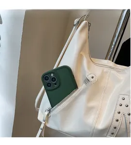 Front zipper pocket of a shiny cream tote bag showing phone storage capacity