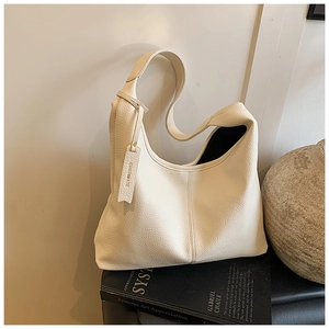 Detailed view of off-white leather tote bag texture with decorative vertical stitching