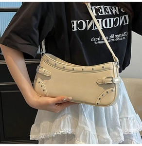Détail du sac baguette crème avec rivets argentés et boucle de style vintage rétro