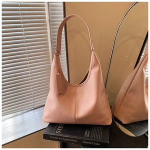 Detailed macro view of the textured lychee leather and stitching on this pink hobo tote bag
