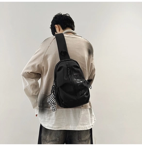 Close-up of black sports chest bag with water-resistant fabric and checkerboard charm