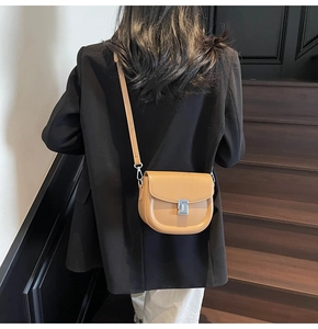 Detailed back view of a light brown leather saddle bag featuring silver metal buckle