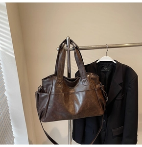 Detail view of brown vintage leather tote bag with X-stitch reinforcement and long straps