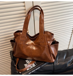 Detailed view of deep brown vintage tote bag with functional pockets on a leather seat