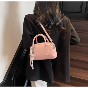 Detailed macro view of pink litchi grain leather mini pillow bag with round handles