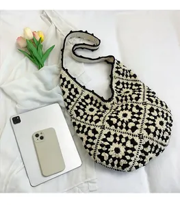 Handwoven black and white floral hobo tote shown next to an iPad for size reference