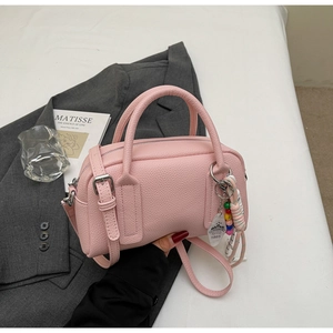 Detailed macro view of pink Boston bag with pebbled leather texture and colorful beads