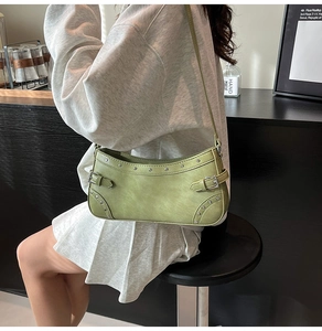 Détail du sac sous l'aisselle en cuir verni vert vintage avec rivets et boucles style Y2K