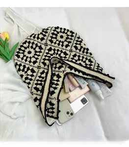 Detail showing high capacity of the black and white crochet tote bag with daily essentials