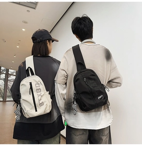 Close-up of sporty nylon chest bag with BTXBD logo and checkered bear keychain