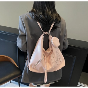 Detail of pink large tote bag featuring silver M-shaped rivet and small round coin purse