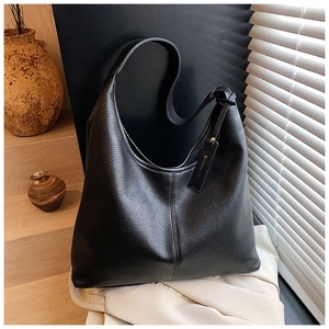 Detailed view of black pebbled leather texture on a hobo bag with a brand logo tag