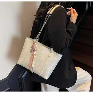 Detail of off-white leather tote bag with silver chain strap and checkered silk scarf