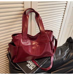 Detail view of burgundy leather tote bag showing side pockets and texture on seat