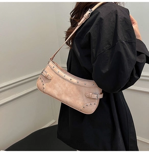Détail du sac hobo en daim rose abricot avec clous argentés sur la bandoulière