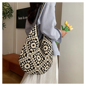 Detail of hand-knitted tote bag featuring black and white floral crochet patterns