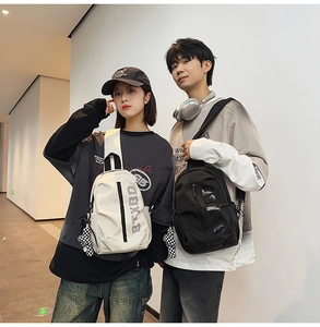 Outdoor street style shot of couples wearing black and white nylon chest bags with bear charms
