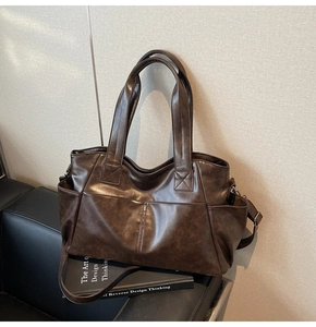 Detail of dark brown tote bag with cross-stitch reinforcement and side pockets