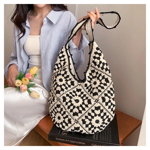 Detail of bohemian crochet tote bag featuring black and white flower knit patterns