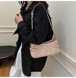 Gros plan du sac sous le bras rose en similicuir avec rivets argentés et boucles