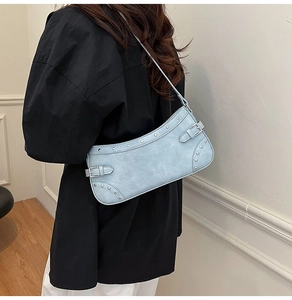 Détail du sac baguette bleu clair avec rivets argentés vintage et boucles métalliques