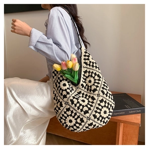 Close-up of a crochet granny square tote bag showing black and white geometric weaving