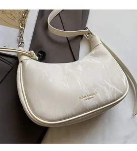 Detail of off-white marble texture underarm bag with silver chain and gold lettering