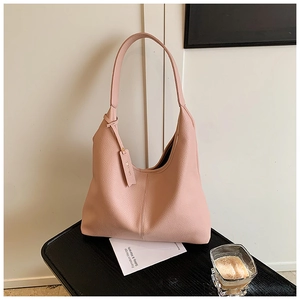 Detailed view of pink lychee leather hobo bag texture and wide shoulder strap