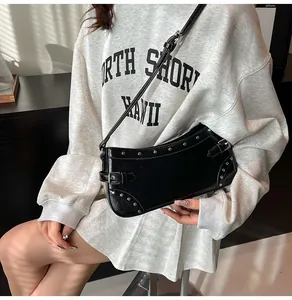 Détail du sac à bandoulière noir avec rivets argentés et finition en similicuir poli