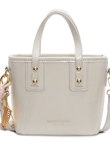Elegant off-white bucket bag with dual handles and gold lettering on a clean background
