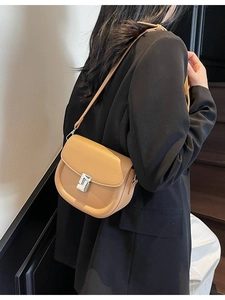 Classic camel saddle bag for women with geometric silver metal buckle on minimalist background