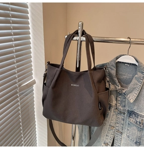 Dettaglio della borsa tote in tela grigio scuro con logo MIDOLAI e tracolla staccabile