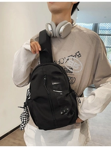 Black casual chest bag with 3D BARD lettering and a checkered bear charm on a model