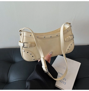 Détail du sac bandoulière en similicuir beige avec rivets argentés et boucle déco