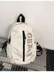 Minimalist beige sports crossbody bag with BTXBD logo and checkered charm on a metal rack