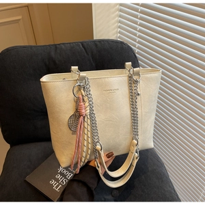 Detail view of off-white tote bag with chain strap and vintage textured PU leather