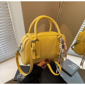 Detail of yellow boston bag with pebble grain leather texture and 1865 tag