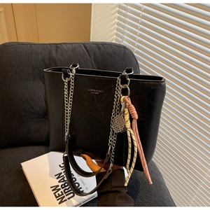 Detail of black tote bag with silver chain strap, tennis pendant and printed logo