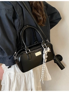 Glossy black Boston handbag with silver heart charm and adjustable crossbody strap