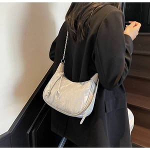 Silver crescent underarm bag with marble texture and chain strap on female model