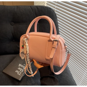 Pink litchi leather pillow bag with woven rope detail and detachable shoulder strap