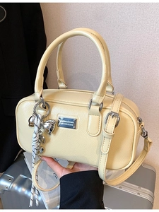 Pale yellow Boston bag in glossy PU leather with metal plaque and bow charm detail