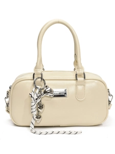 Elegant beige Boston bag with shiny finish featuring a decorative bow and heart pendant