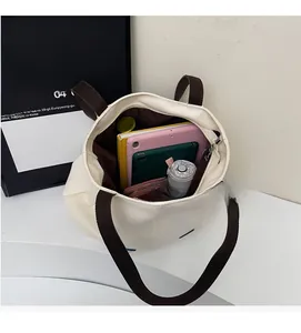 Top view of large white canvas tote bag showing spacious interior with tablets and books